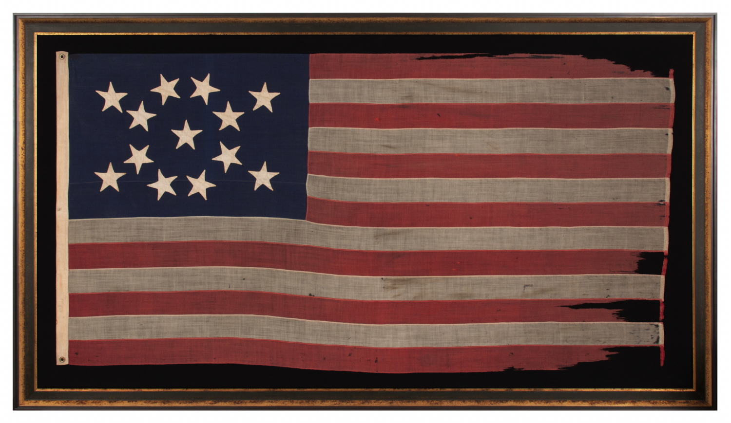 13 STAR ANTIQUE AMERICAN FLAG WITH HAND-SEWN STARS IN AN UNUSUAL, ELONGATED FORM OF THE MEDALLION CONFIGURATION AND ENDEARING WEAR FROM LONG-TERM USE, MADE IN THE ERA OF THE 1876 CENTENNIAL OF AMERICAN INDEPENDENCE