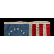 13 HAND-EMBROIDERED STARS AND EXPERTLY HAND-SEWN STRIPES ON AN ANTIQUE AMERICAN FLAG MADE IN PHILADELPHIA BY SARAH M. WILSON, GREAT-GRANDDAUGHTER OF BETSY ROSS, SIGNED & DATED 1910; THE LARGEST KNOWN EXAMPLE OF THIS VARIETY, MADE AND SOLD TO TOURISTS AT INDEPENDENCE HALL