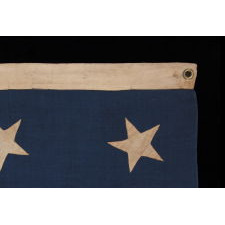 13 HAND-SEWN STARS IN A 3-2-3-2-3 PATTERN ON AN ANTIQUE AMERICAN FLAG OF THE 1876 CENTENNIAL ERA, POSSIBLY A U.S. NAVY SMALL BOAT ENSIGN