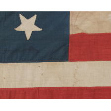 13 HAND-SEWN STARS ARRANGED IN A 3-2-3-2-3 PATTERN, WITH VARYING VERTICAL ORIENTATION, ON A HOMEMADE ANTIQUE AMERICAN FLAG DATING TO THE ERA OF THE 1876 CENTENNIAL OF AMERICAN INDEPENDENCE