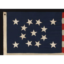 13 HAND-SEWN STARS IN A BEAUTIFUL MEDALLION CONFIGURATION ON A SMALL SCALE ANTIQUE AMERICAN FLAG OF THE 1876 CENTENNIAL ERA