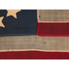 13 HAND-SEWN STARS IN A CIRCULAR VERSION OF THE 3RD MARYLAND PATTERN, MADE DURING THE CIVIL WAR PERIOD OR IMMEDIATELY THEREAFTER, IN A GREAT SMALL SCALE AMONG ITS COUNTERPARTS OF THE PERIOD WITH PIECED-AND-SEWN CONSTRUCTION