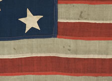 13 HAND-SEWN STARS ON A FLAG WITH ELONGATED PROPORTIONS, IN A RARE, SMALL SIZE FOR THE PERIOD, 1876 CENTENNIAL ERA