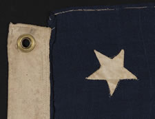 13 HAND-SEWN, UPSIDEDOWN STARS, IN THE 4-5-4 PATTERN, ON AN EXTREMELY SMALL SCALE FLAG WITH ITS CANTON RESTING ON THE "WAR STRIPE", MADE BETWEEN 1864 AND THE 1876 CENTENNIAL OF AMERICAN INDEPENDENCE