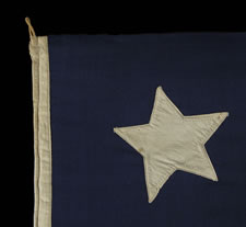 13 LARGE STARS IN THE 4-5-4 PATTERN ON A BEAUTIFULLY GRAPHIC FLAG MADE BETWEEN 1864 AND THE 1876 CENTENNIAL OF AMERICAN INDEPENDENCE,  A U.S. NAVY SMALL BOAT ENSIGN