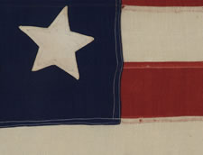 13 LARGE STARS IN THE 4-5-4 PATTERN ON A BEAUTIFULLY GRAPHIC FLAG MADE BETWEEN 1864 AND THE 1876 CENTENNIAL OF AMERICAN INDEPENDENCE,  A U.S. NAVY SMALL BOAT ENSIGN