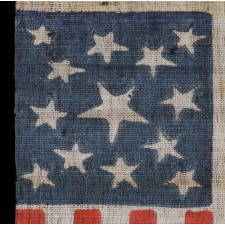 13 STAR AMERICAN PARADE FLAG MADE BETWEEN THE CIVIL WAR (1861-65) AND THE 1876 CENTENNIAL OF AMERICAN INDEPENDENCE, FEATURING THREE SIZES OF WHIMSICALLY SHAPED STARS IN A MEDALLION CONFIGURATION