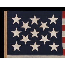 13 STAR ANTIQUE AMERICAN FLAG, A U.S. NAVY SMALL BOAT ENSIGN WITH ENORMOUS HAND-SEWN STARS, IN A REMARKABLE STATE OF PRESERVATION, MADE CA 1890-1899