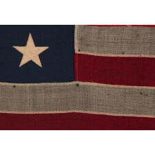 13 STAR ANTIQUE AMERICAN FLAG WITH A BEAUTIFUL MEDALLION CONFIGURATION OF STARS; A SMALL-SCALE EXAMPLE, MADE CIRCA 1895-1926