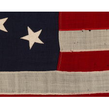 13 STAR ANTIQUE AMERICAN FLAG WITH A MEDALLION CONFIGURATION OF STARS; A SMALL-SCALE EXAMPLE, MADE circa 1895-1926