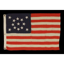 13 STAR ANTIQUE AMERICAN FLAG WITH A MEDALLION CONFIGURATION OF STARS; A SMALL-SCALE EXAMPLE, MADE circa 1895-1926