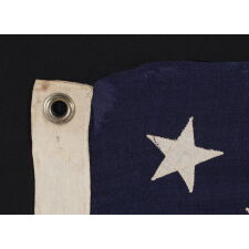 13 STAR ANTIQUE AMERICAN FLAG WITH A MEDALLION CONFIGURATION OF STARS; A SMALL-SCALE EXAMPLE, MADE circa 1895-1926