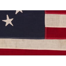 13 STAR ANTIQUE AMERICAN FLAG WITH A CIRCULAR VERSION OF WHAT IS KNOWN AS THE 3RD MARYLAND PATTERN, MADE BETWEEN APPROXIMATELY 1910 AND THE WWII ERA