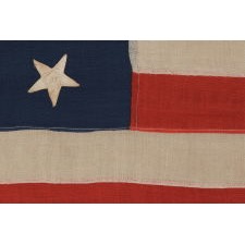 13 STARS IN A 3-2-3-2-3 LINEAL CONFIGURATION ON AN ANTIQUE AMERICAN FLAG MADE IN NEW YORK CITY BY JOHN BOYLE & COMPANY, CA 1885-1900, WITH AN UNUSUAL, BLACK-INKED STENCIL ALONG THE HOIST THAT READS “BOYLE’S YACHT SAIL”