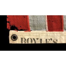 13 STARS IN A 3-2-3-2-3 LINEAL CONFIGURATION ON AN ANTIQUE AMERICAN FLAG MADE IN NEW YORK CITY BY JOHN BOYLE & COMPANY, CA 1885-1900, WITH AN UNUSUAL, BLACK-INKED STENCIL ALONG THE HOIST THAT READS “BOYLE’S YACHT SAIL”