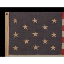 13 STARS IN A 3-2-3-2-3 PATTERN ON A DUSTY BLUE CANTON, ON A SMALL-SCALE, ANTIQUE AMERICAN FLAG WITH AN ELONGATED PROFILE, MADE DURING THE LAST DECADE OF THE 19TH CENTURY, CA 1890-1895