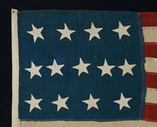 13 STARS IN A 4-5-4 CONFIGURATION, ENTIRELY HAND-SEWN, A U.S. NAVY SMALL BOAT ENSIGN WITH A SMALL CANTON AND AN ELONGATED FORMAT, MADE SOMETIME BETWEEN 1850 AND THE OPENING YEARS OF THE CIVIL WAR (1861-1863)