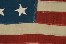 13 STARS IN A 4-5-4 CONFIGURATION, ENTIRELY HAND-SEWN, A U.S. NAVY SMALL BOAT ENSIGN WITH A SMALL CANTON AND AN ELONGATED FORMAT, MADE SOMETIME BETWEEN 1850 AND THE OPENING YEARS OF THE CIVIL WAR (1861-1863)