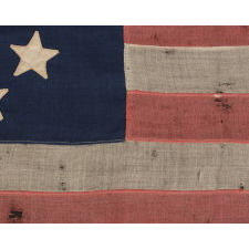 13 STARS IN A CIRCULAR VERSION OF THE 3RD MARYLAND PATTERN, ON A SMALL SCALE FLAG PROBABLY DATING TO THE FIRST HALF OF THE 1890'S, WITH ENDEARING PRESENTATION FROM EXTENDED USE