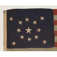 13 STARS IN A MEDALLION CONFIGURATION ON A SMALL-SCALE ANTIQUE AMERICAN FLAG OF THE 1890-1900 ERA, WITH AMPLE WEAR AND LOSSES