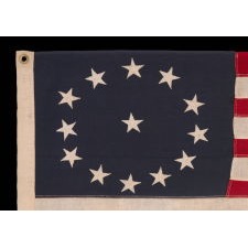 13 STARS IN AN OVAL VERSION OF THE 3RD MARYLAND PATTERN, ON A SMALL SCALE, ANTIQUE AMERICAN FLAG MADE BETWEEN APPROXIMATELY 1926 AND THE WWII ERA