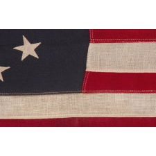 13 STARS IN AN OVAL VERSION OF THE 3RD MARYLAND PATTERN, ON A SMALL SCALE, ANTIQUE AMERICAN FLAG MADE BETWEEN APPROXIMATELY 1926 AND THE WWII ERA