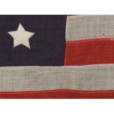 13 STARS WITH SHORT, CONICAL ARMS, ARRANGED IN A MEDALLION CONFIGURATION ON A SMALL SCALE FLAG MADE DURING THE LAST DECADE OF THE 19TH CENTURY, POSSIBLY OF PHILADELPHIA ORIGIN