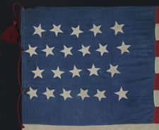 22 STARS, A SOUTHERN-EXCLUSIONARY FLAG, WITH AN ODDLY PLACED LINEAL STAR FIELD AND LARGE, HAND-MADE RED WOOLEN TASSELS ON A RED WOOLEN CORD, PROBABLY MADE BETWEEN 1863 AND 1864