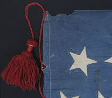 22 STARS, A SOUTHERN-EXCLUSIONARY FLAG, WITH AN ODDLY PLACED LINEAL STAR FIELD AND LARGE, HAND-MADE RED WOOLEN TASSELS ON A RED WOOLEN CORD, PROBABLY MADE BETWEEN 1863 AND 1864