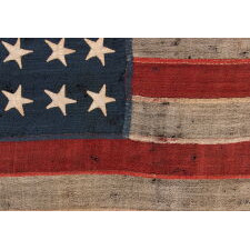 24 STAR ANTIQUE AMERICAN FLAG, MADE IN THE PERIOD WHEN MISSOURI WAS THE MOST RECENT STATE TO JOIN THE UNION, 1821-1836, EXTRAORDINARILY RARE, WITH ITS CANTON RESTING ON THE “WAR STRIPE” OR “BLOOD STRIPE," AND IN A REMARKABLY TINY SCALE AMONG FLAGS OF THIS ERA