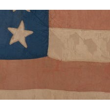 31 STARS IN A 6-6-7-6-6 LINEAL PATTERN, WITH SCATTERED ORIENTATION, ON AN ANTIQUE AMERICAN FLAG MADE OF SILK AND WITH THE BLUE CANTON RESTING ON THE WAR STRIPE, CALIFORNIA STATEHOOD, 1850-1858, LIKELY HAND-CARRIED INTO THE CIVIL WAR BY A MILITIA UNIT