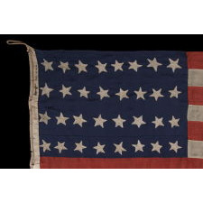 32 STARS ON AN ANTIQUE AMERICAN FLAG WITH ITS CANTON RESTING ON THE WAR STRIPE, MADE IN THE PERIOD WHEN MINNESOTA JOINED THE UNION AS THE 32nd STATE; A VERY RARE STAR COUNT, OFFICIAL FOR JUST ONE YEAR, AND ACCURATE FOR JUST NINE MONTHS, 1858-59