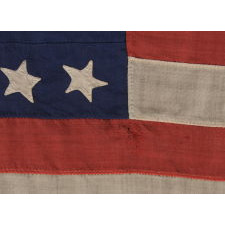 32 STARS ON AN ANTIQUE AMERICAN FLAG WITH ITS CANTON RESTING ON THE WAR STRIPE, MADE IN THE PERIOD WHEN MINNESOTA JOINED THE UNION AS THE 32nd STATE; A VERY RARE STAR COUNT, OFFICIAL FOR JUST ONE YEAR, AND ACCURATE FOR JUST NINE MONTHS, 1858-59