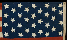 32 STARS, AN ESPECIALLY RARE, PRE-CIVIL WAR STAR COUNT, ON A RARE, SMALL SCALE, HOMEMADE FLAG, WITH ITS CANTON RESTING ON THE WAR STRIPE, 1858-59, MINNESOTA STATEHOOD