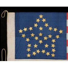 34 GILT PAINTED STARS IN A BOLD REPRESENTATION OF THE “GREAT STAR” PATTERN, ON A SILK, ANTIQUE AMERICAN FLAG MADE DURING THE OPENING YEARS OF THE CIVIL WAR, 1861-63, PROBABLY MADE UNDER MILITARY CONTRACT OR FOR USE BY LOCAL MILITIA, ENTIRELY HAND-SEWN, IN A TINY SCALE FOR THE PERIOD