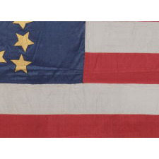 34 GILT PAINTED STARS IN A BOLD REPRESENTATION OF THE “GREAT STAR” PATTERN, ON A SILK, ANTIQUE AMERICAN FLAG MADE DURING THE OPENING YEARS OF THE CIVIL WAR, 1861-63, PROBABLY MADE UNDER MILITARY CONTRACT OR FOR USE BY LOCAL MILITIA, ENTIRELY HAND-SEWN, IN A TINY SCALE FOR THE PERIOD