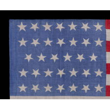 34 STARS ON AN ANTIQUE AMERICAN FLAG, PRINTED ON SILK, WITH "DANCING" OR "TUMBLING" ORIENTATION, CIVIL WAR PERIOD, 1861-1863, REFLECTS THE ADDITION OF KANSAS TO THE UNION AS A FREE STATE