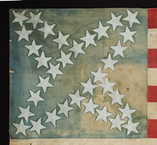 34 STARS IN A CROSS MEDALLION PATTERN THAT IS UNIQUE TO THIS FLAG, CIVIL WAR PERIOD, 1861-63 ENTIRELY HAND-SEWN, WITH WHITE-PAINTED STARS