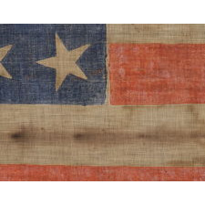 34 STARS WITH SCATTERED ORIENTATION ON A RARE, LARGE SCALE, CIVIL WAR PERIOD PARADE FLAG WITH ENDEARING WEAR FROM OBVIOUS EXTENDED USE, KANSAS STATEHOOD, 1861-63