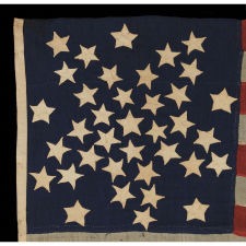 37 STARS IN A WHIMSICAL REPRESENTATION OF THE "GREAT STAR" PATTERN WITH A STAR BETWEEN EACH ARM, ON A HAND-SEWN FLAG IN A REMARKABLY TINY SCALE FOR THE PERIOD, PROBABLY 1867-1876, NEBRASKA STATEHOOD, AN EXCEPTIONAL EXAMPLE