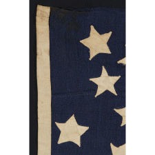 37 STARS IN A WHIMSICAL REPRESENTATION OF THE "GREAT STAR" PATTERN WITH A STAR BETWEEN EACH ARM, ON A HAND-SEWN FLAG IN A REMARKABLY TINY SCALE FOR THE PERIOD, PROBABLY 1867-1876, NEBRASKA STATEHOOD, AN EXCEPTIONAL EXAMPLE