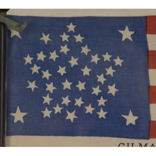 38 STAR ANTIQUE AMERICAN FLAG WITH A RARE AND BEAUTIFUL VARIATION OF THE "GREAT STAR" OR "GREAT LUMINARY" PATTERN, AN EXAMPLE OF EXTRAORDINARY QUALITY, MADE BY R.W. MUSGROVE IN BRISTOL, NEW HAMPSHIRE FOR AN 1885 REUNION OF THE 12th NH VOLUNTEERS