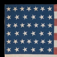 39 STARS WITH BOTH DANCING AND CANTED POSITIONING, ALTERNATING FROM ROW-TO-ROW, ON AN ANTIQUE AMERICAN FLAG LIKELY MADE FOR THE 1876 CENTENNIAL, NEVER AN OFFICIAL STAR COUNT, REFLECTS THE ANTICIPATED ARRIVAL OF THE DAKOTA TERRITORY