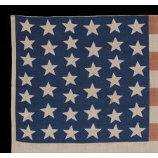 39 STARS IN TWO SIZES, ALTERNATING FROM ONE COLUMN TO THE NEXT, ON AN ANTIQUE AMERICAN PARADE FLAG DATING TO THE 1876 CENTENNIAL, NEVER AN OFFICIAL STAR COUNT, REFLECTS THE ANTICIPATED ARRIVAL OF COLORADO AND THE DAKOTA TERRITORY