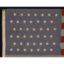 42 HAND-SEWN STARS ON SMALL SCALE FLAG WITH A DUSTY BLUE CANTON, AN UNOFFICIAL STAR COUNT, WASHINGTON STATEHOOD, 1889-1890