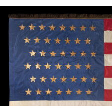 43 GILT-PAINTED STARS ON A SILK, ANTIQUE AMERICAN FLAG WITH BULLION FRINGE; REFLECTS THE ADDITION OF IDAHO AS THE 43RD STATE ON JULY 3RD, 1890, ONE OF THE RAREST STAR COUNTS AMONG SURVIVING AMERICAN FLAGS OF THE 19TH CENTURY