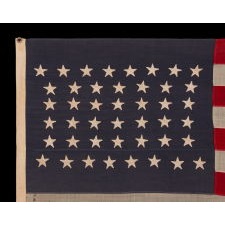 44 STAR FLAG WITH BEAUTIFULLY HAND-SEWN STARS IN AN HOURGLASS PATTERN ON A SOLDIER BLUE CANTON, AN ANTIQUE EXAMPLE; REFLECTS THE ADDITION OF WYOMING 1890-1896