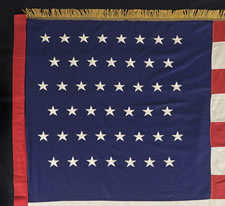 45 STARS, A VERY UNUSUAL MILITARY BATTLE FLAG, MADE OF MERINO WOOL WITH EMBROIDERED STARS, BOUND WITH BULLION TAPE AND TRIMMED WITH GOLD SILK FRINGE, UTAH STATEHOOD, 1896-1907, SPANISH-AMERICAN WAR ERA