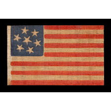 7 STARS WITH WHIMSICAL PROFILES ON AN ANTIQUE AMERICAN PARADE FLAG, MADE TO REFLECT THE INITIAL WAVE OF 7 STATES SECEDED FROM THE UNION, A CIVIL WAR PERIOD EXAMPLE, THE LARGEST OF SEVERAL KNOWN VARIETIES, MADE circa 1861