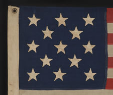 ANTIQUE AMERICAN FLAG WITH 13 HAND-SEWN STARS IN A 3-2-3-2-3 CONFIGURATION, IN AN EXTREMELY SCARCE, SMALL SIZE FOR THE PERIOD, 1876 CENTENNIAL ERA